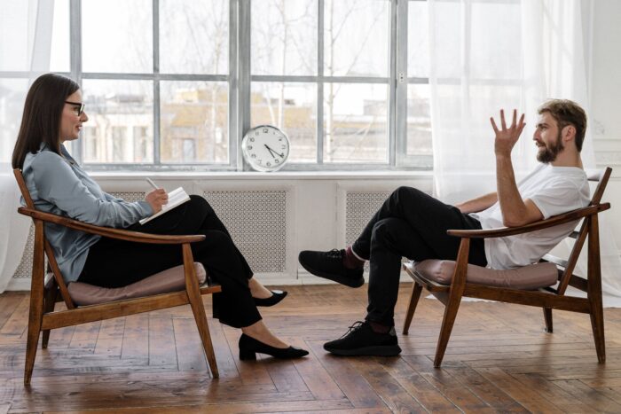 clinical psychologist (person in black pants and black shoes sitting on brown wooden chair)