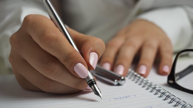 person hands woman pen - setting new goals