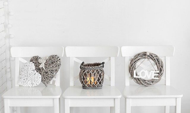 shabby chic look - picture of 3 chairs, each wine wire decorations on it. the first chair has two wooden woven hearts, the next is a wooden wove lantern with a light inside and the last one is of a wreath.