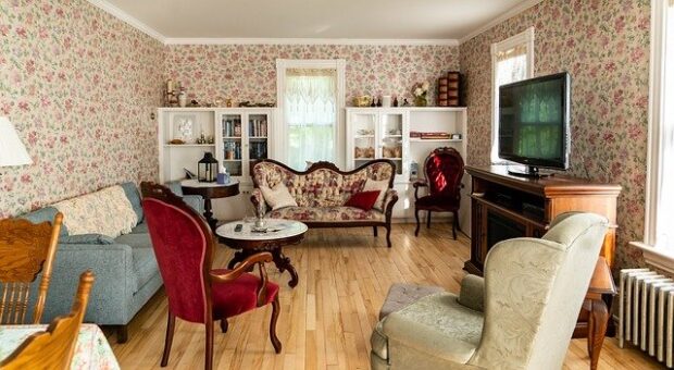 shabby chic look - room featuring many victorian styles. There's two settees, 3 armchairs and four shelving units and also a tv on a victorian unit. There are also two small tables.