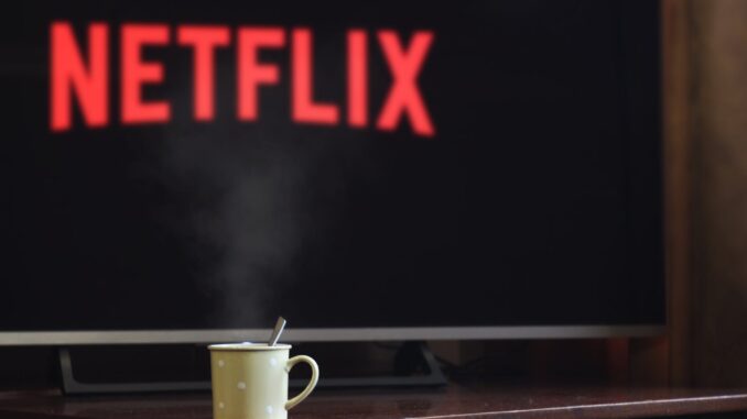 photo of cup near flat screen television - watching netflix is better for the eco conscious.