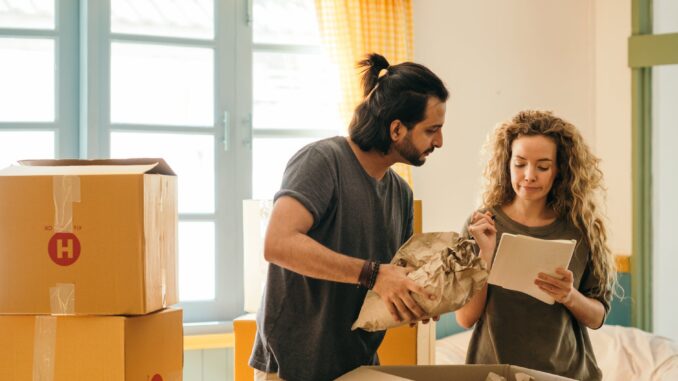 happy couple unpacking boxes in new home - Cohabiting Couples: Your rights and the law