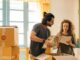 happy couple unpacking boxes in new home - Cohabiting Couples: Your rights and the law