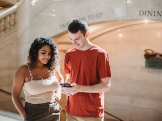 positive young multiethnic couple browsing smartphone during trip in new york - Six Social media trends you will be obsessed with in 2021