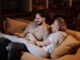 man and woman sitting on couch
