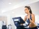 What are the 10 most popular gym songs? - young female athlete training alone on treadmill in modern gym