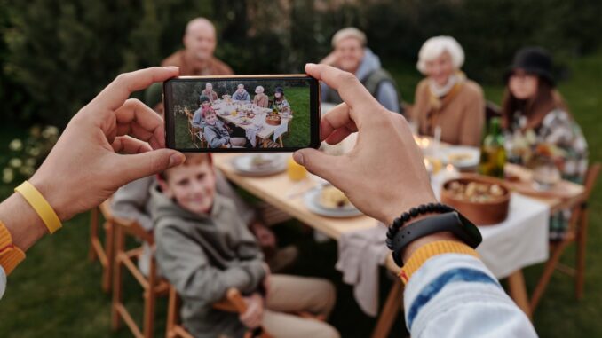 unrecognizable person taking photo of family dinner on smartphone - 8 Reasons to Store Family Photos on an External HD
