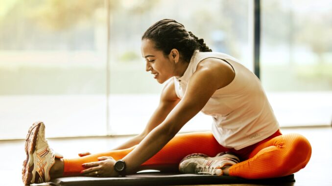 woman stretching on ground - rest day