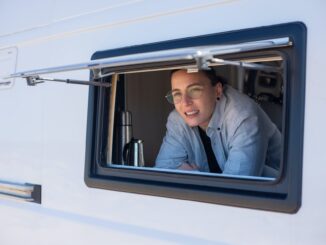 man in blue denim jacket sitting on white and black vehicle seat