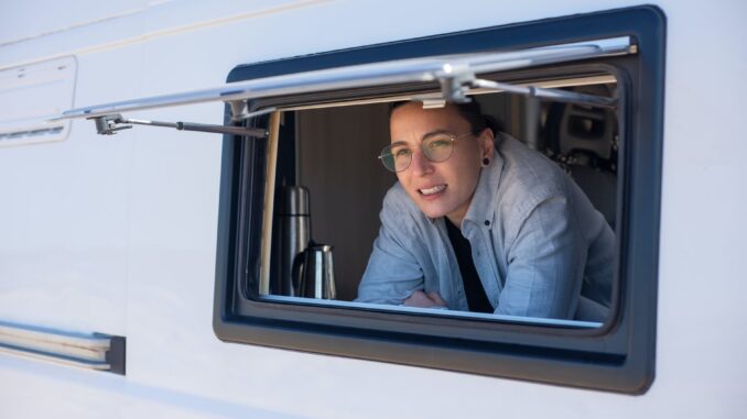 man in blue denim jacket sitting on white and black vehicle seat