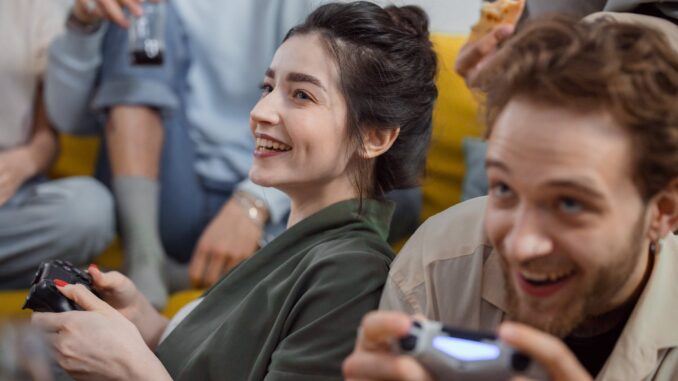 smiling woman in black shirt holding silver smartphone - Research Reveals The Nationalities That Cheat The Most At Video Games