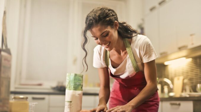 happy woman with rolling pin cooking at home