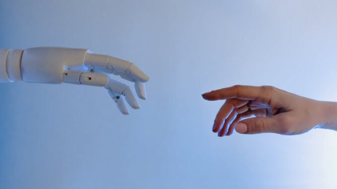 person reaching out to a robot - Can Artificial Intelligence be dangerous?