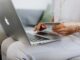 online shopping leads to overspending - person using a macbook and holding a credit card