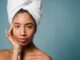calm young ethnic woman with perfect skin touching face after shower - 4 Myths about Wearing Sunscreen in the Winter