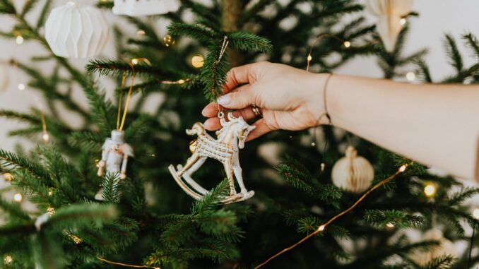 Over 2 million Brits make the naughty list and admit to cheating on their partner at a work Christmas party person holding rocking horse christmas ornament
