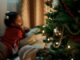 girl in red sweater lying down on pillows - THE Perfect Time To Decorate For Christmas