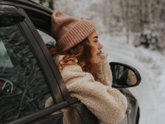 person with beanie in a car - Protect your car from the perils of winter with these 6 key tips