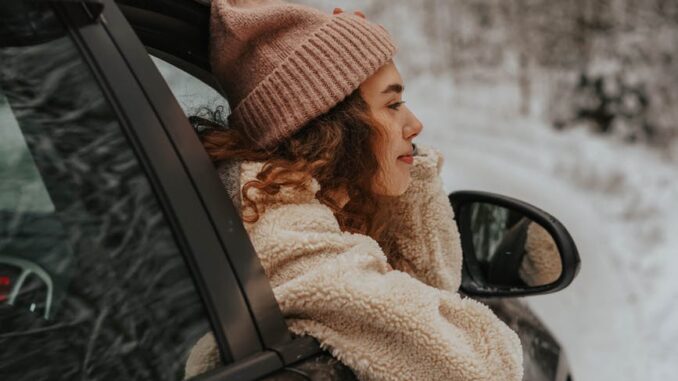 person with beanie in a car - Protect your car from the perils of winter with these 6 key tips