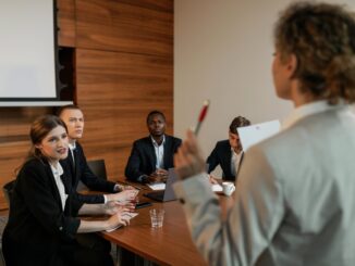 woman in beige business suit holding red and silver ballpen - 'Burnout build-up': 221% surge in demand for burnout support, causing employee exodus HR warning