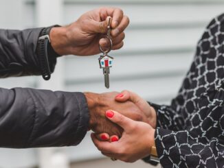 person holding silver key - Astrologist reveals your dream home according to your star sign