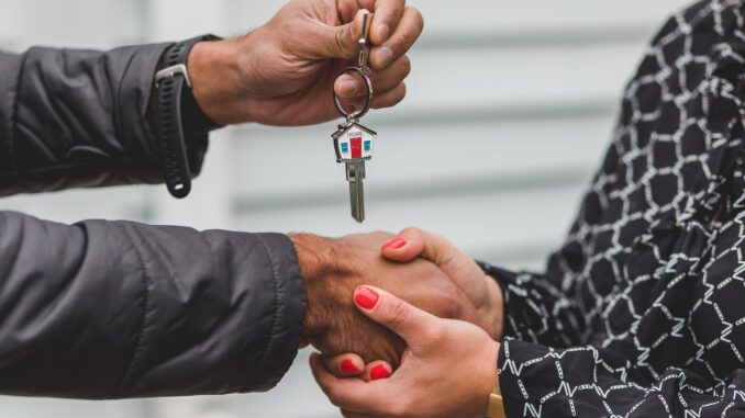 person holding silver key - Astrologist reveals your dream home according to your star sign