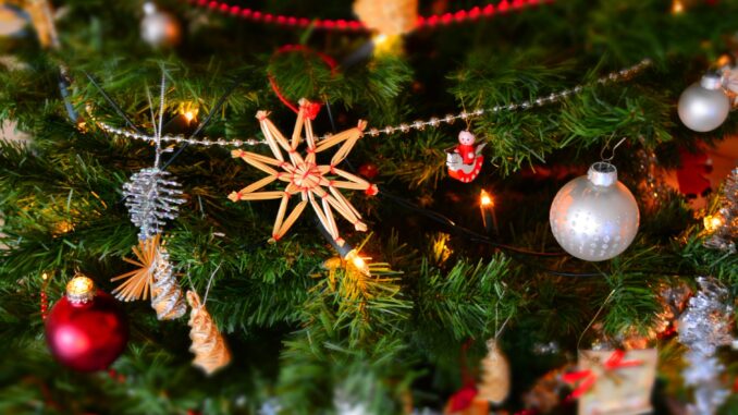close up of christmas decoration hanging on tree - the true cost of christmas