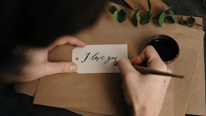 person holding white printer paper - looking for love