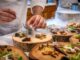 chef preparing vegetable dish on tree slab - Restaurant Options