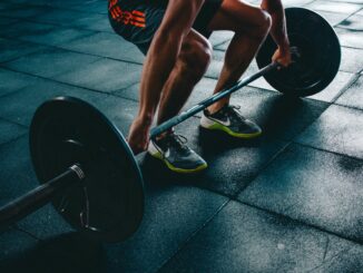 person holding barbell - Study Reveals The UK Cities That Take The Most Gym Selfies
