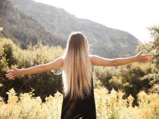 standing man in black dress facing mountain