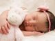 baby sleeping with animal plush toy