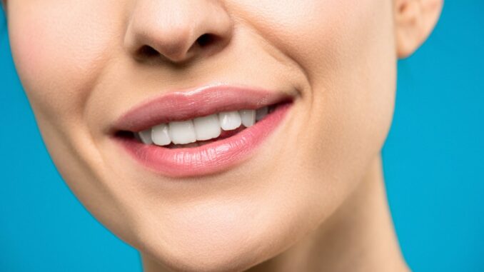 close up photo of woman with pink lipstick smiling